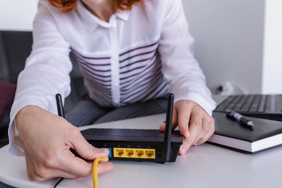 An AuraNet technician professionally installing a Wi-Fi router in a modern home.